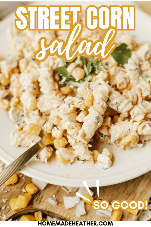 A close-up of a creamy street corn salad with pasta, corn, red onion, and cilantro on a white plate. A fork holds a bite. Text reads Street Corn Salad and So Good! with a website link at the bottom.